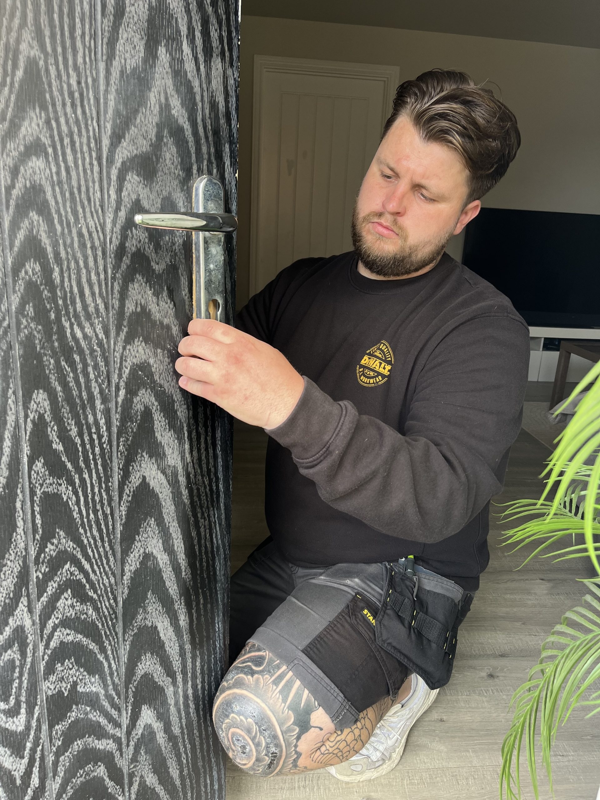 Seymour Locksmiths locksmith checking the handle and lock on a front door